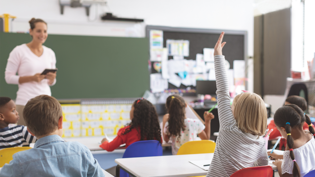 teacher in elementary classroom full of students