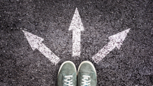 view looking down on two on a street with three arrows pointing in different directions